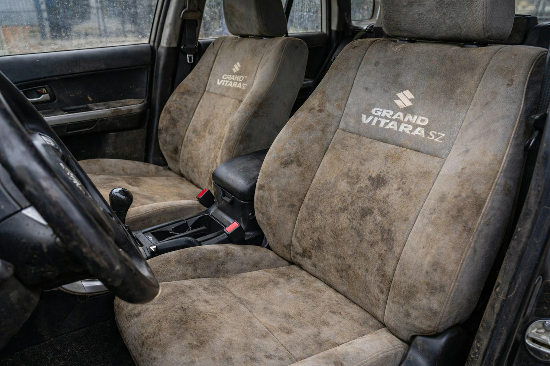 Verwaarloosde autostoel met vlekken en stof